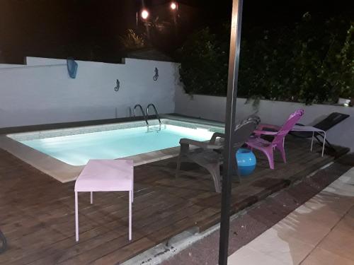 une piscine avec deux chaises et une table dans l'établissement Chez Yannick et Isabelle, à Saint-Nazaire