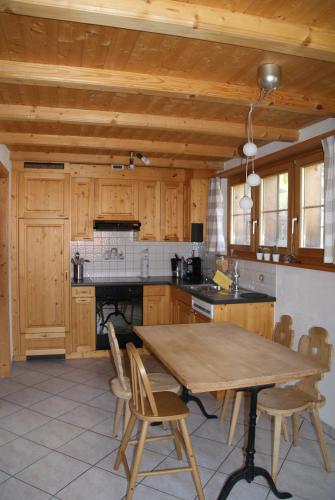 cocina grande con mesa de madera y sillas en Ferienwohnung Lenzerheide-Sporz, en Lenzerheide