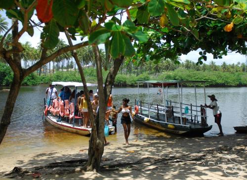 a group of people on boats in the water at Pousada Capitù in Imbassai