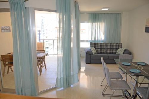 ein Wohnzimmer mit einem Sofa und einem Tisch in der Unterkunft Apartment Sincera in Benidorm