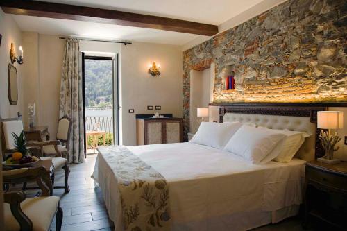 a bedroom with a large bed and a stone wall at Boutique Hotel Elvezia in Stresa
