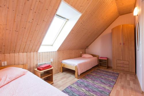 a attic bedroom with two beds and a window at Vetsi Talli Holiday Village in Kassari