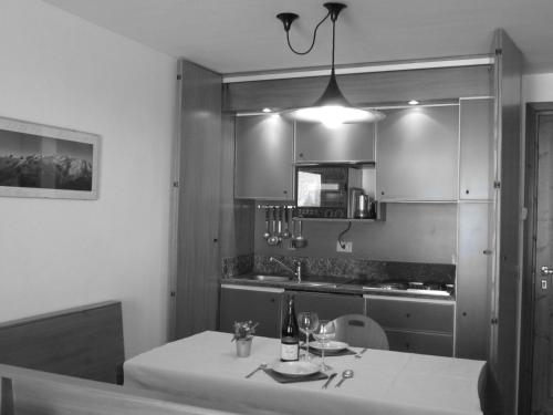 a kitchen with a table with wine bottles on it at Il Piccolo Residence in Gressoney-la-Trinité