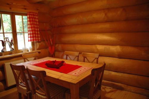 una mesa y sillas en una habitación con una pared de madera en Sosnowa Chata, en Jelenia Góra-Jagniątków