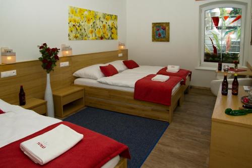 a bedroom with two beds with red and white towels at Penzión Minipivovar Tatras in Poprad