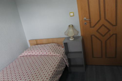 a bedroom with a bed and a lamp next to a door at Guest House Ohrid Trpeski in Ohrid