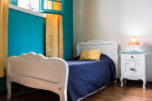 a small bedroom with a bed and a night stand at Hostal Forestal in Santiago