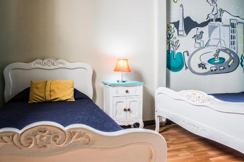 a bedroom with two beds and a table with a lamp at Hostal Forestal in Santiago