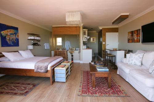 a bedroom with a bed and a living room at Dolphin Inn Guesthouse in Cape Town