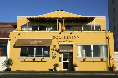 un edificio giallo con un cartello che legge dophin in sinagoga di Dolphin Inn Guesthouse a Città del Capo