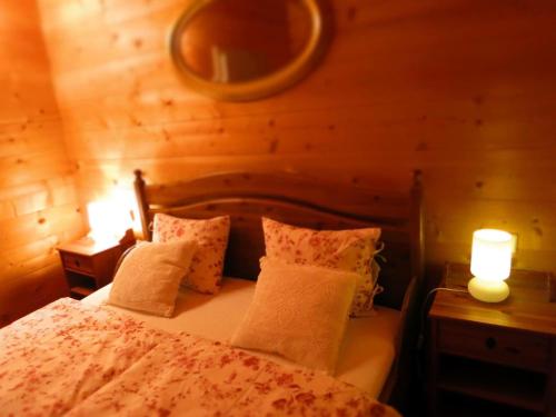 een slaapkamer met een bed met kussens en 2 lampen bij Apartment-Foelslhof in Siegsdorf