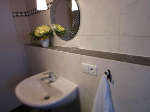 een badkamer met een wastafel en een spiegel bij Apartment-Foelslhof in Siegsdorf