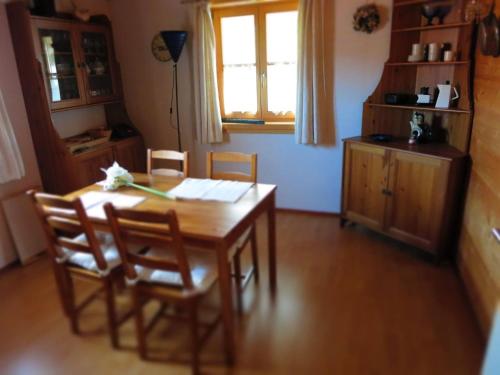 ein Esszimmer mit einem Tisch, Stühlen und einem Fenster in der Unterkunft Apartment Foelslhof in Siegsdorf