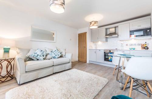 a living room with a white couch and a kitchen at The Chapel Chester - Boutique Apartments in Chester