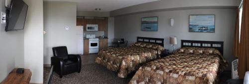 a hotel room with two beds and a kitchen at Alberta Beach Inn and Suites in Albert Beach (Alberta)