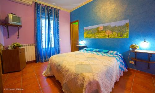 sypialnia z łóżkiem i telewizorem w obiekcie Agriturismo La Valle degli Ulivi w mieście Semproniano