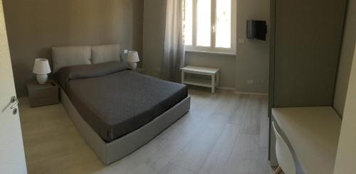 a bedroom with a bed and a window and a television at Sanremo Luxury Apartament in Sanremo