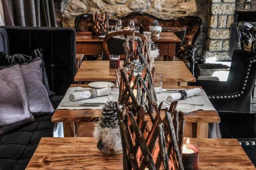 a dining room with wooden tables and chairs at Hôtel Bella Tola & SPA in Saint-Luc