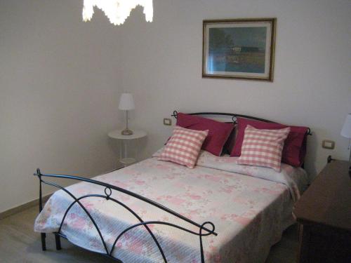 ラ・スペツィアにあるurania houseのベッドルーム1室(赤と白の枕が備わるベッド1台付)