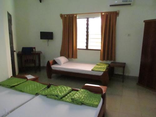 a room with two beds and a window at Paradise Ocean Resort in Cape Coast