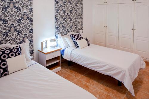 two beds in a small room with blue and white wallpaper at Sunset View And Pool In Paradise in Adeje