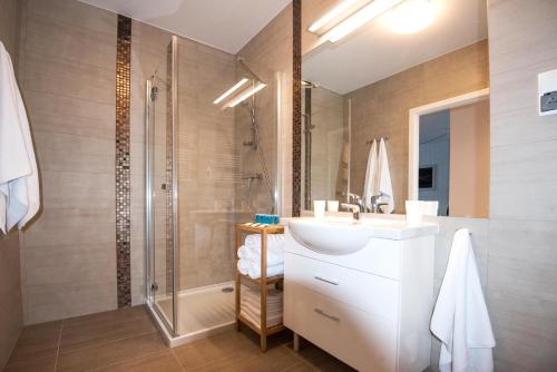 y baño con lavabo y ducha. en LATO apartament Solna 11c z garażem en Kołobrzeg