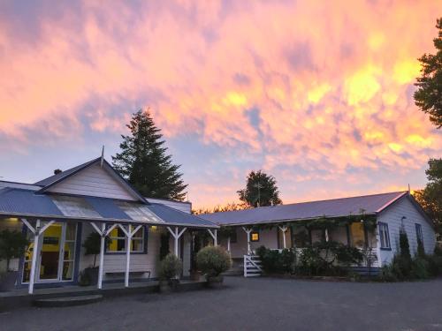 a building with a sunset in the sky at Tongariro Crossing Lodge in National Park