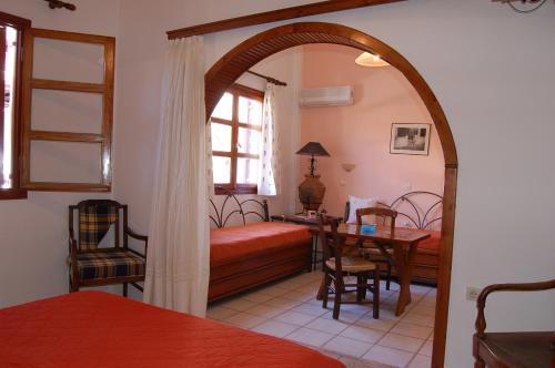 Schlafzimmer mit einem Bett und einem Tisch mit einem Schreibtisch in der Unterkunft Patras Rooms est 1990 in Fourni Ikaria