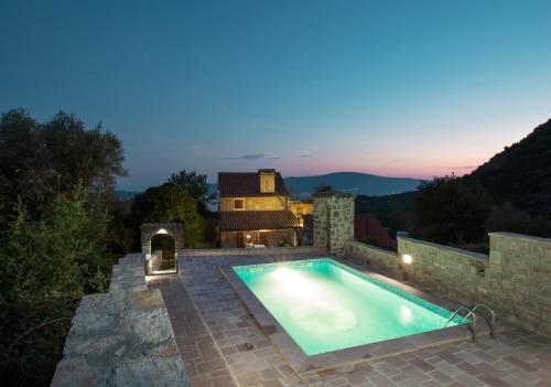 a swimming pool in the backyard of a house at Old Stone House Villas in Tivat