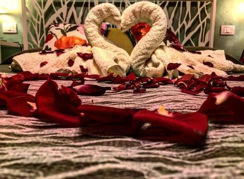 a bed with two swans and roses on it at Affittacamere Casa Mac & Rose in San Quirico dʼOrcia