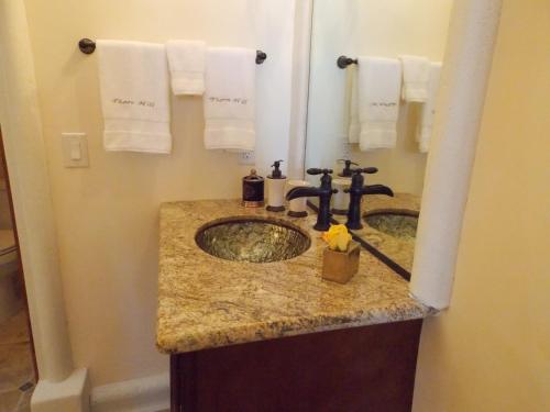 un bagno con lavandino e asciugamani appesi a una parete di Thorn Hill Vineyards Villa Suites a Clear Lake Riviera