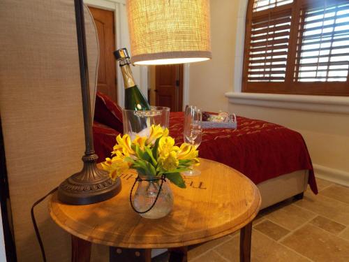 una stanza con un tavolo con una lampada e fiori di Thorn Hill Vineyards Villa Suites a Clear Lake Riviera