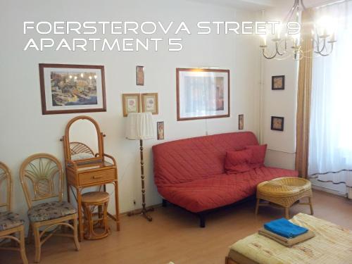 a living room with a red couch and chairs at Holiday Apartments in Karlovy Vary