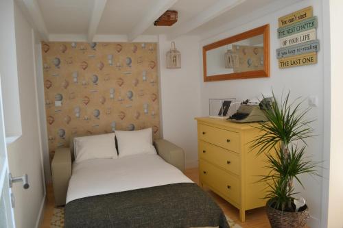 um pequeno quarto com uma cama e uma cómoda em Wood Loft by RDC no Porto