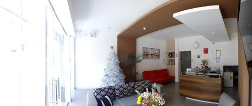 a living room with a couch and a red chair at Hostal Gazu in Chiclayo