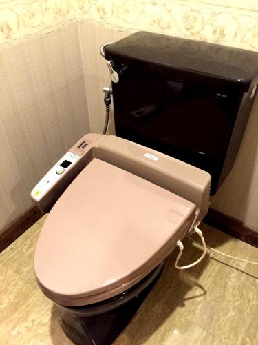 a toilet with a remote control on top of it at Hotel Ohirune Racco Sakai (Adult Only ) in Sakai