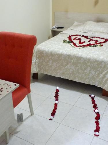 a room with a bed and a chair and christmas decorations at Hostal Gazu in Chiclayo