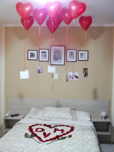 a room with a bed with heart balloons on the wall at Hostal Gazu in Chiclayo
