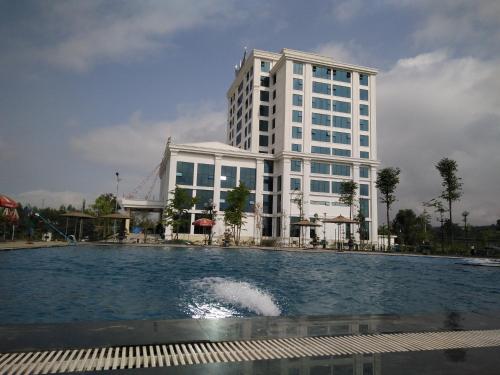 a building with a pool in front of a building at Muong Thanh Holiday Con Cuong in Con Cuông