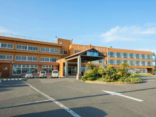 a large building with a parking lot in front of it at Iioka Shiosai Hotel in Asahi