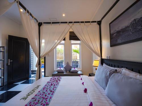 a bedroom with a bed with pink flowers on it at Rithy Rine Angkor Residence in Siem Reap