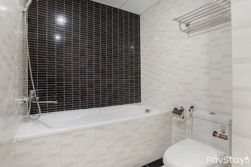a bathroom with a white tub and a toilet and a tub at An Nguyen Building in Hanoi