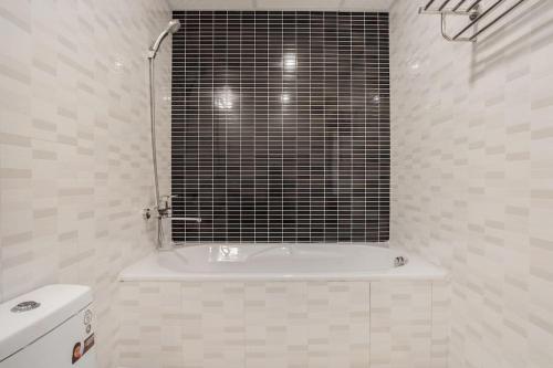 a bathroom with a tub and a toilet and a window at An Nguyen Building in Hanoi