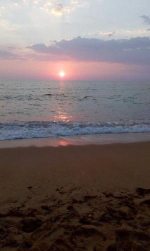 a sunset on a beach with the ocean at B&B Quintino Sella in Iglesias
