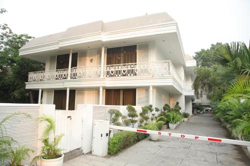 a white house with a balcony and a fence at Diplomat, Chanakyapuri New Delhi- A Boutique Hotel in New Delhi