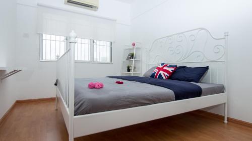 a bedroom with a white bed with two pink pillows at Stay Next to the Event ~ Bukit Jalil Stadium in Kuala Lumpur