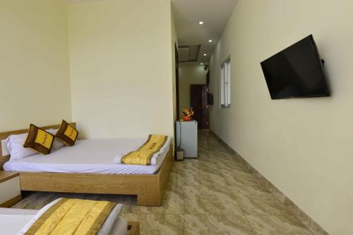 a bedroom with two beds and a flat screen tv at Hung Vuong Hotel in Buon Ma Thuot