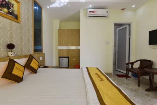a bedroom with a bed and a chair and a television at Hung Vuong Hotel in Buon Ma Thuot