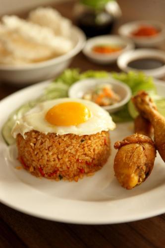 a plate of food with an egg on top at Amaris Hotel Margorejo Surabaya in Surabaya