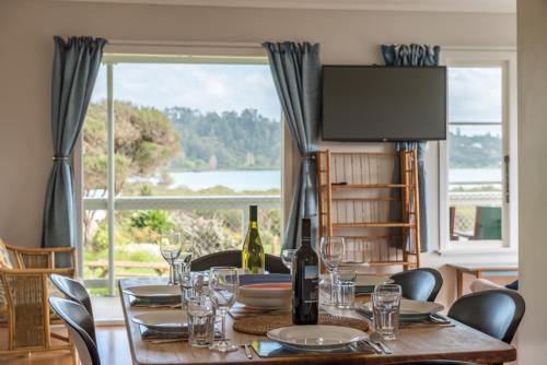 a dining room table with a view of a large window at Russell-Orongo Bay Holiday Park in Russell